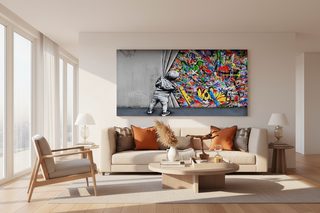 Banksy Boy pulling curtain canvas wall art, vibrant street art on a large canvas above a sofa.