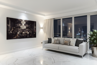 Large black and white "Classic Legends" canvas wall art with a chandelier, above a light grey sofa in a modern room.