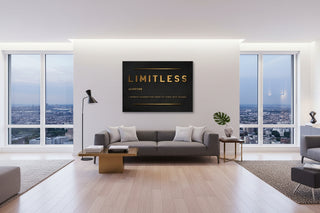 Black "LIMITLESS" motivational canvas wall art with gold text above a gray sofa.