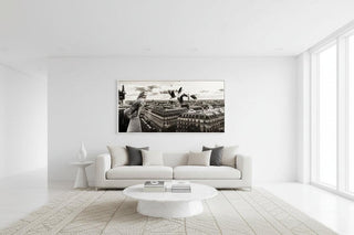 Black and white Marilyn Monroe wall art of her on a balcony overlooking Paris, framed above a white sofa.