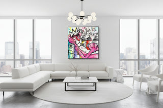 Vibrant Pink Panther graffiti art canvas with spray cans, Bitcoin symbols, and a crown, displayed above a modern tan sofa.